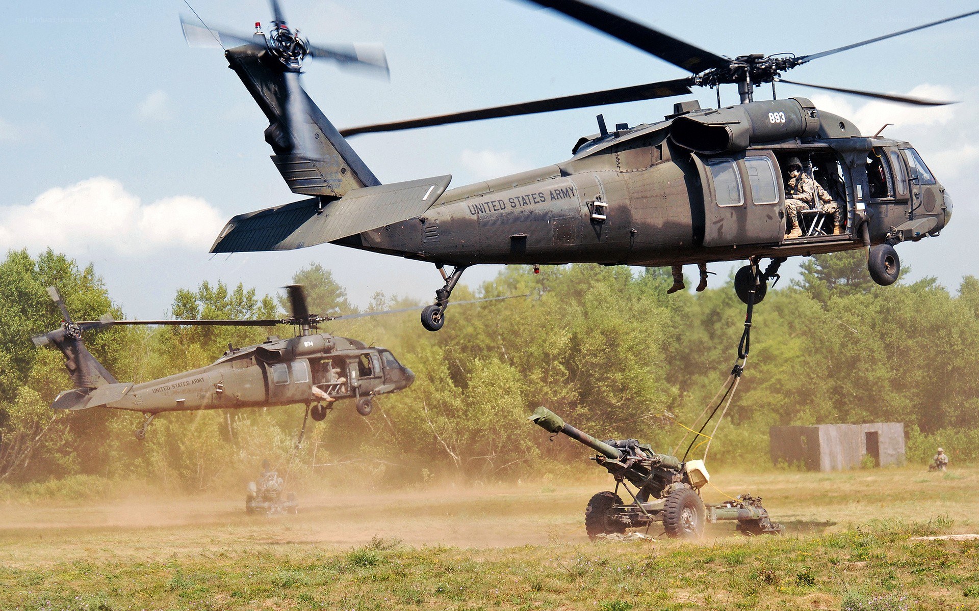 Army helicopters lifting artillery