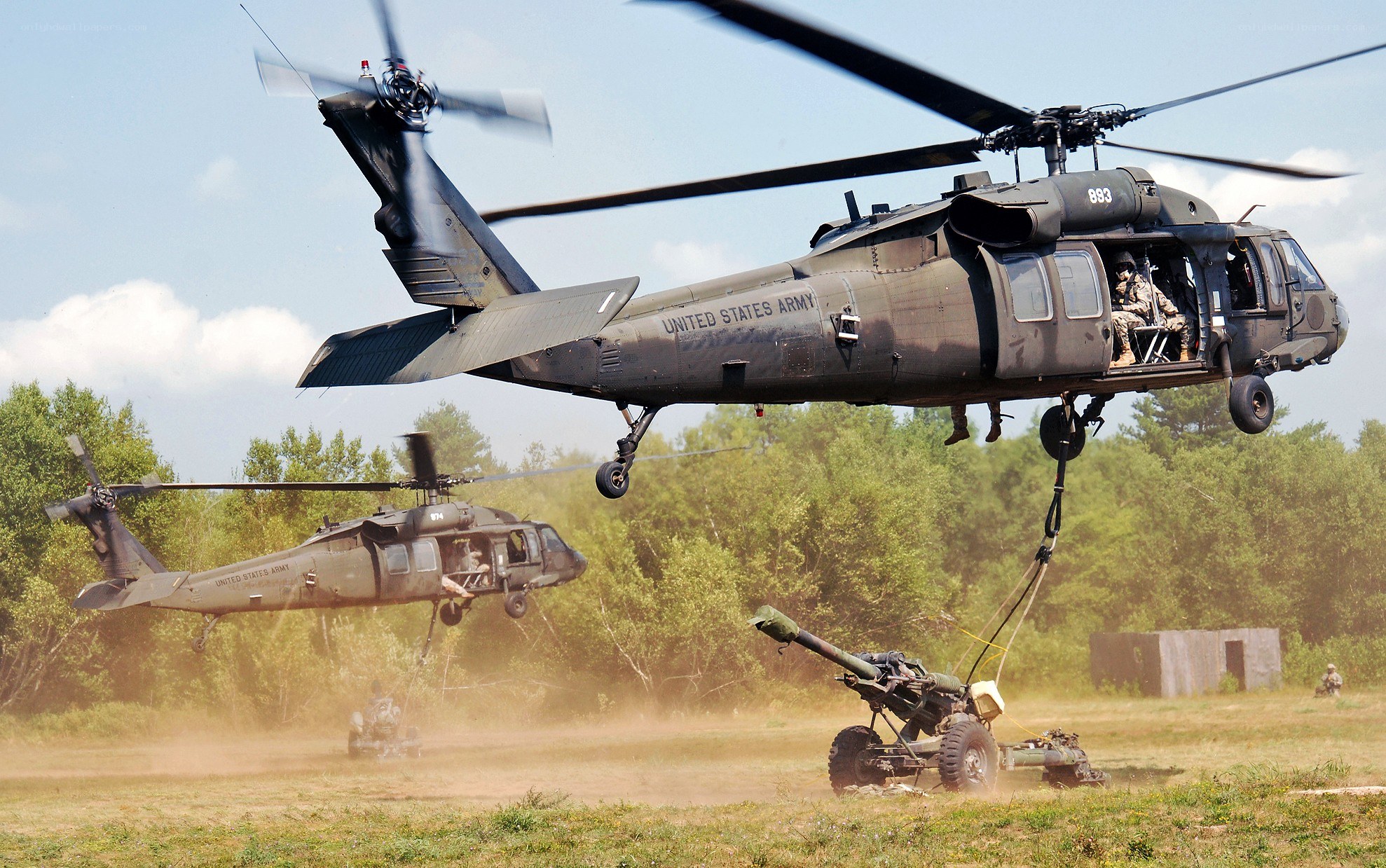 Army helicopters lifting artillery