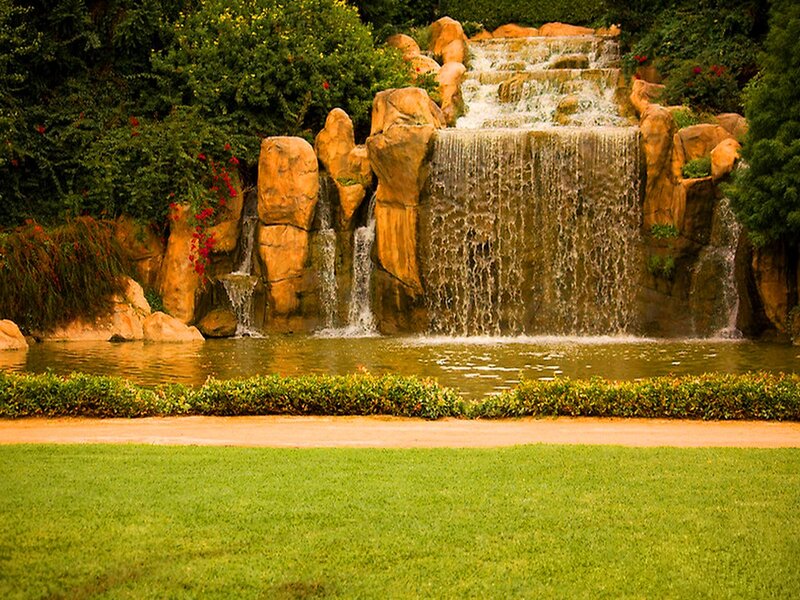 Artificial Waterfall in Garden — Green, Serene, Afternoon, Photograph, Rock Formation