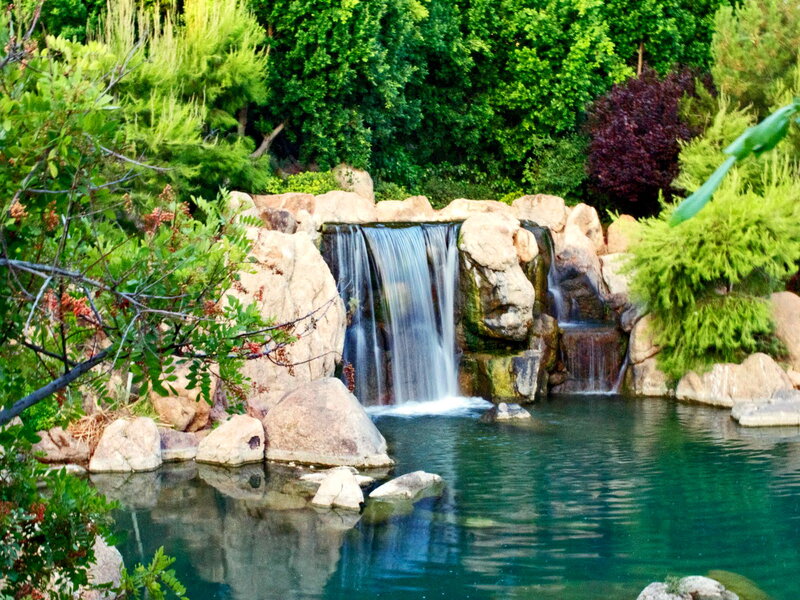 Artificial Waterfall in Garden — Green, Serene, Afternoon, Photograph, Rocks, Trees, Pool