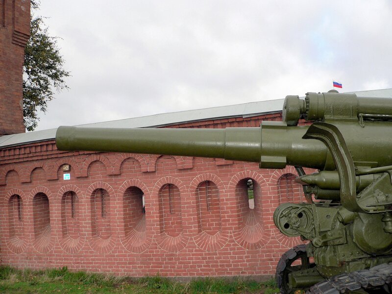 Artillery piece in front of brick wall