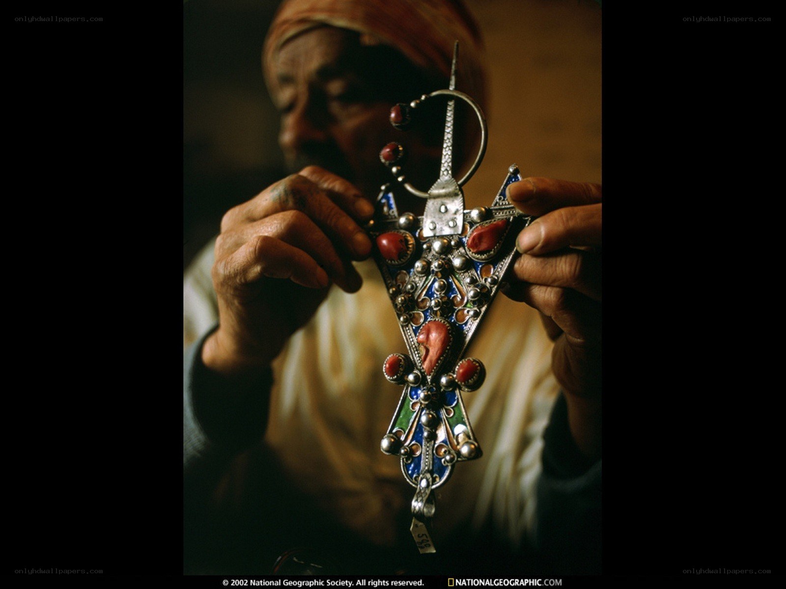 artisan holding ornate pendant