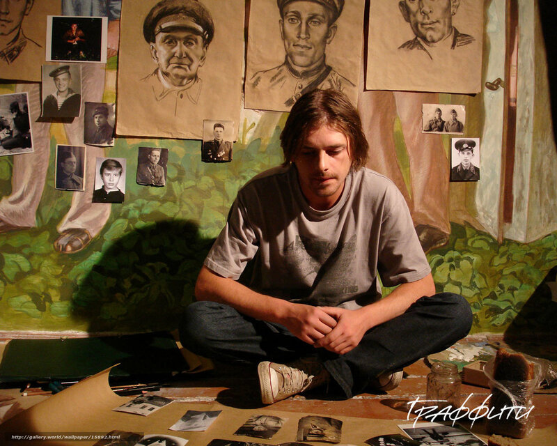 Artist in a studio with portraits
