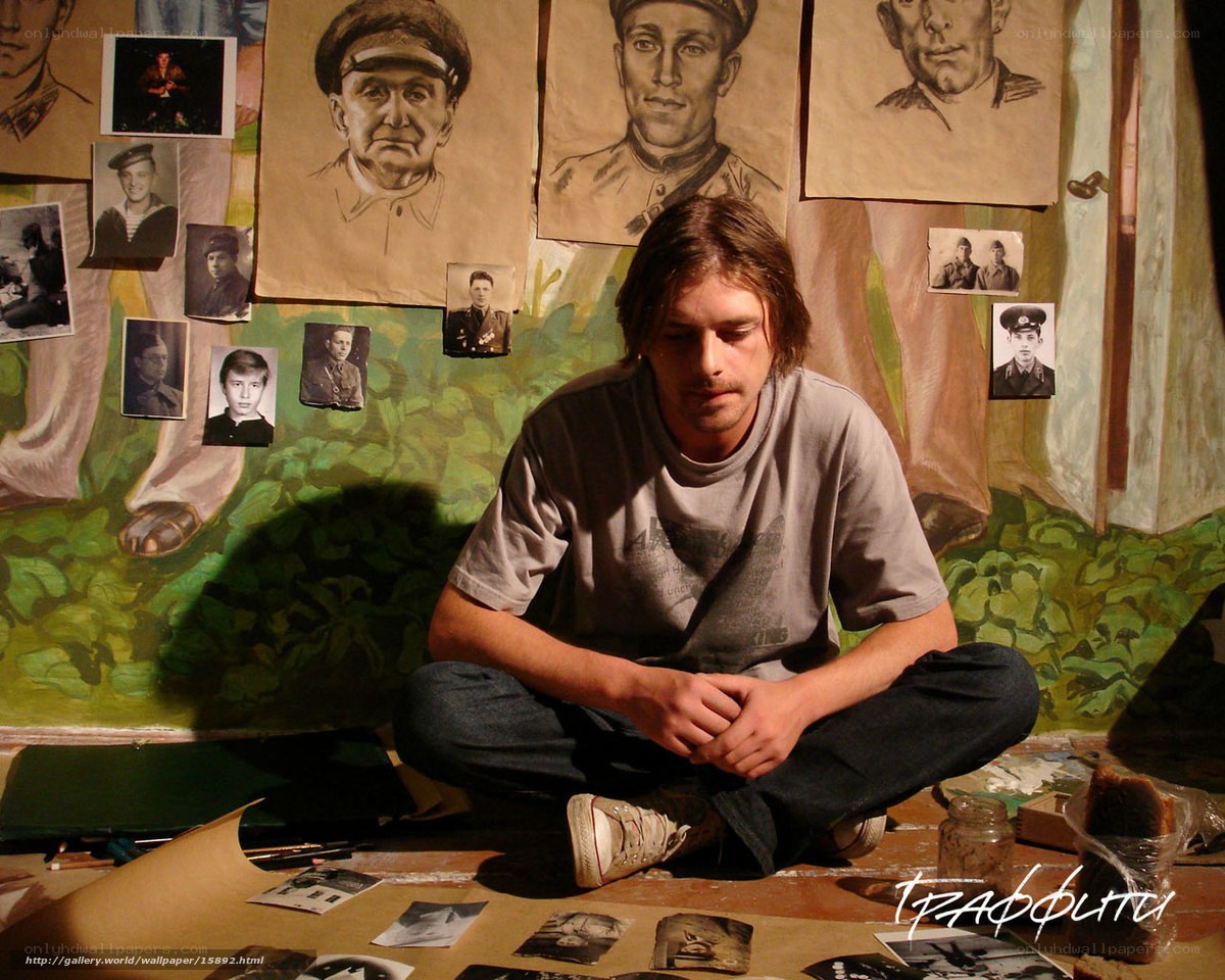 Artist in a studio with portraits