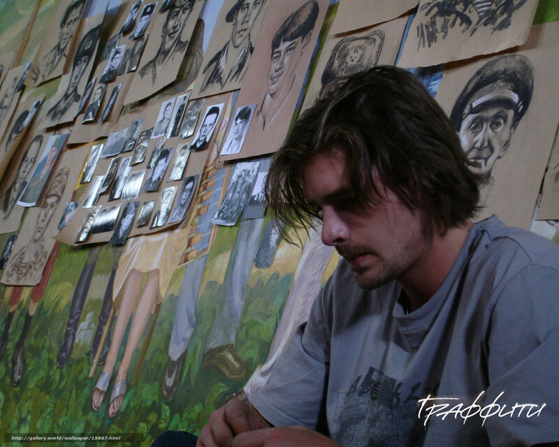artist in studio with portraits