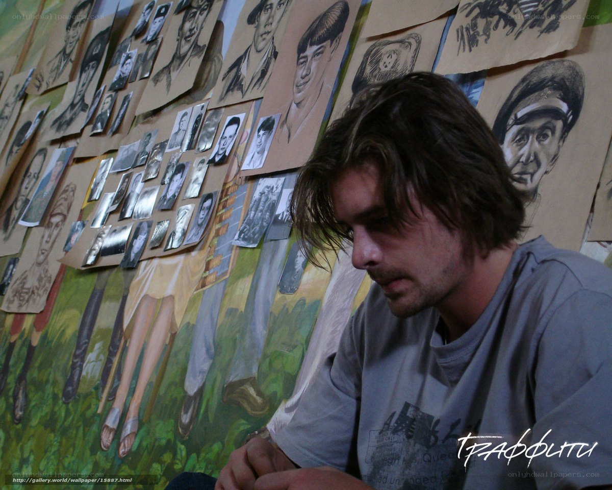 artist in studio with portraits