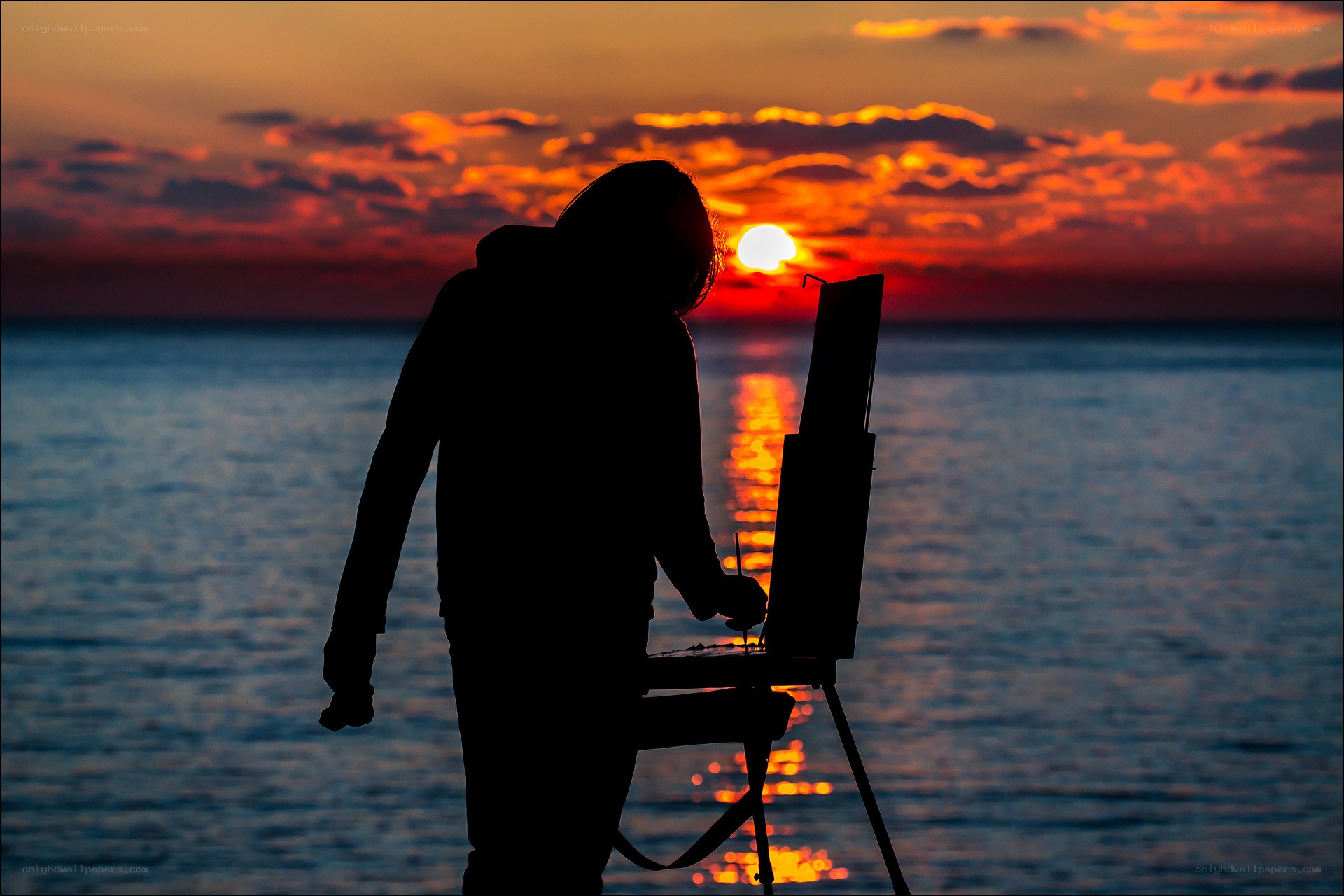 Artist painting at sunset