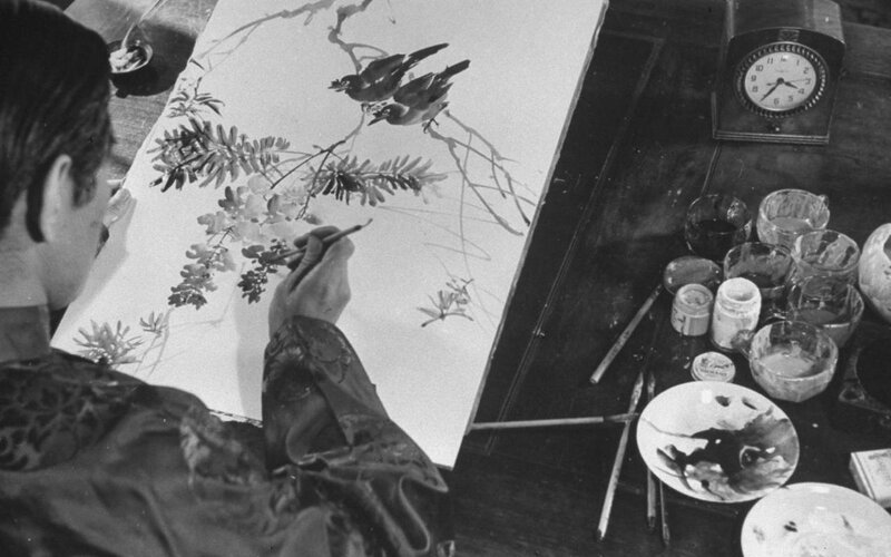 Artist painting birds on paper