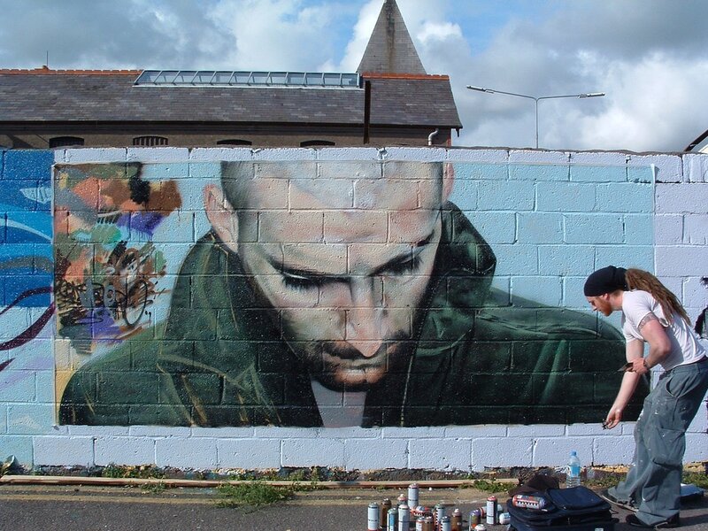 artist painting mural on wall