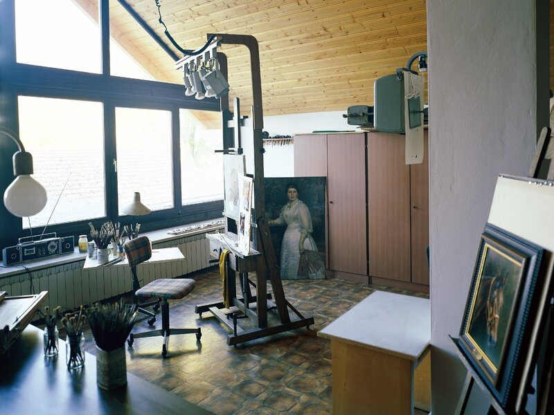 artist's studio with easel and paintings
