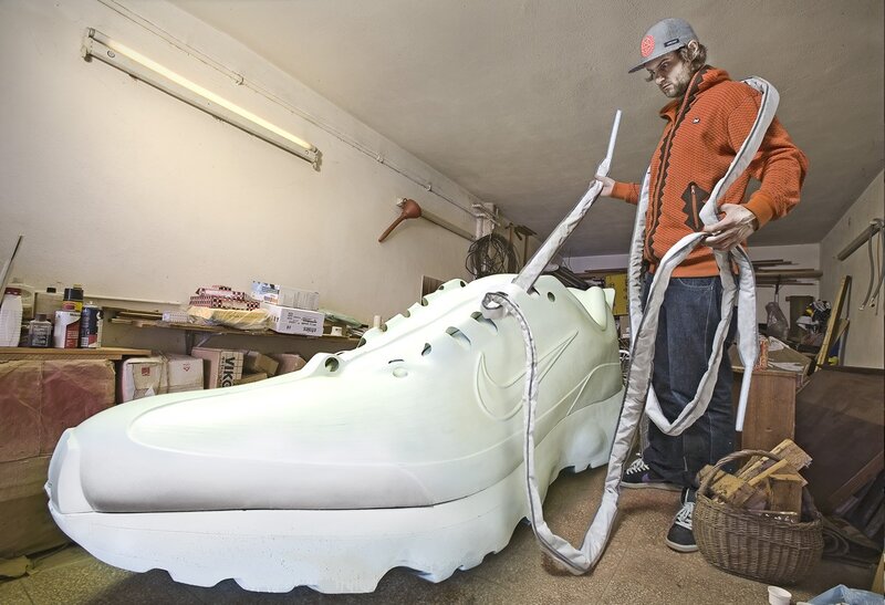 Artist with giant shoe sculpture
