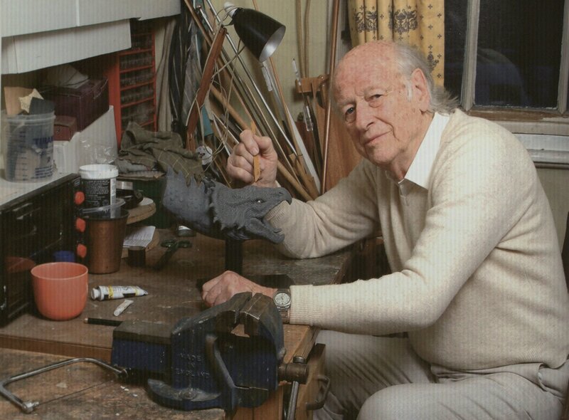 Artist working on a dragon sculpture