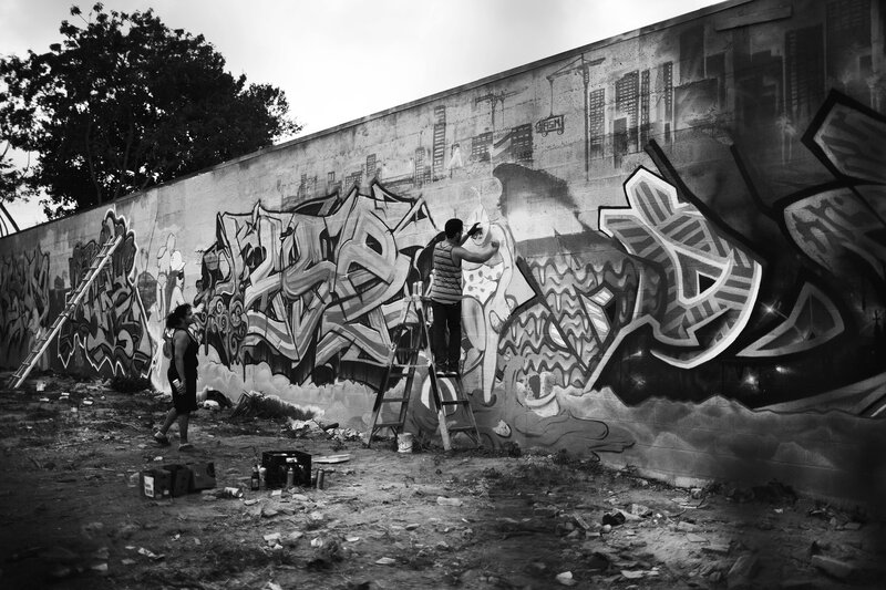 Artists creating a mural on a wall