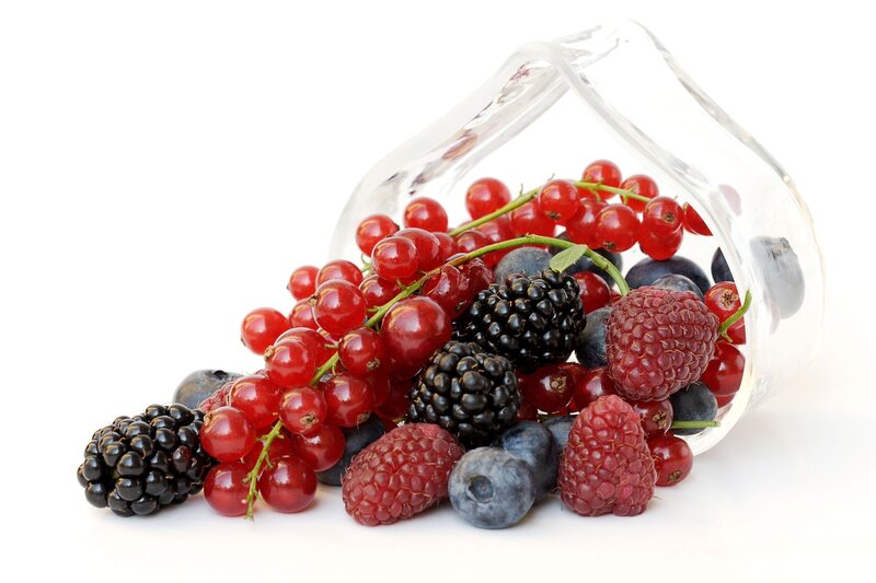 assorted berries spilling from glass
