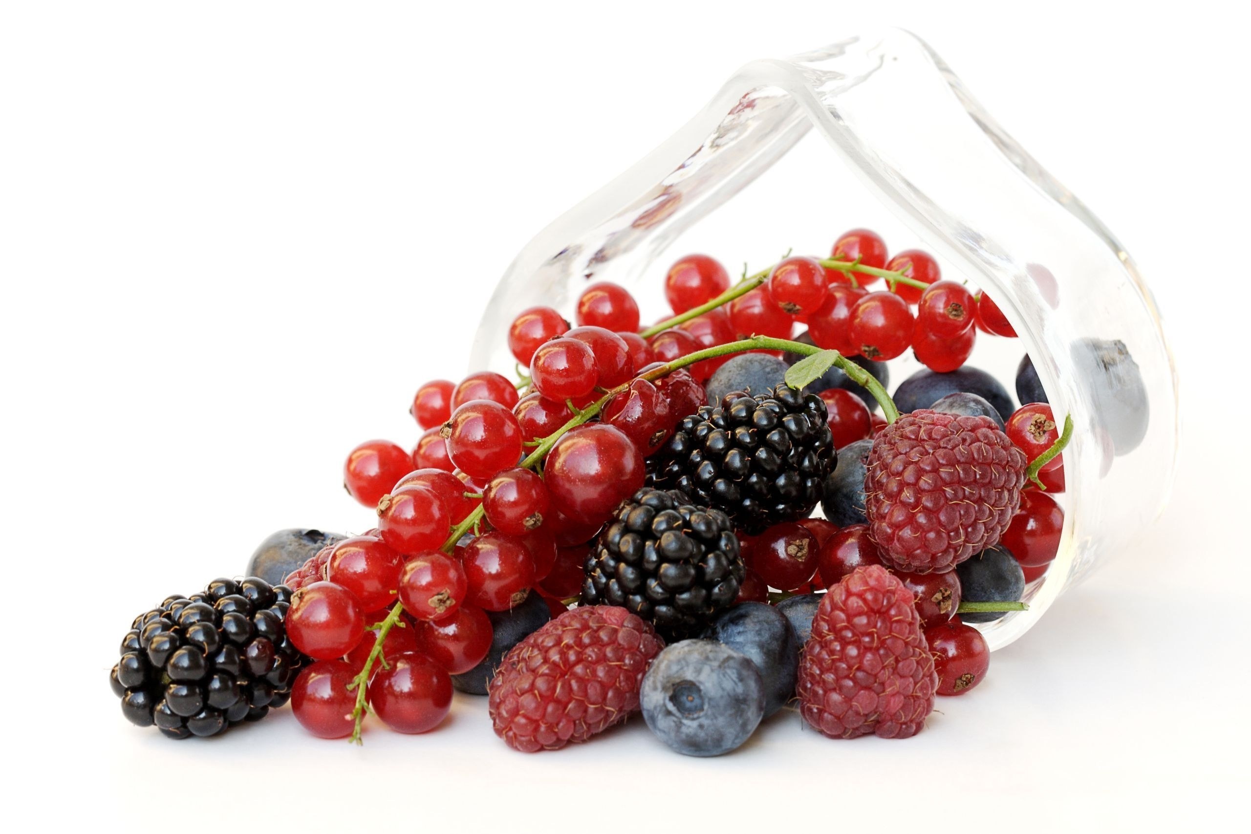 assorted berries spilling from glass