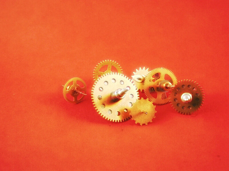 assorted brass gears on red