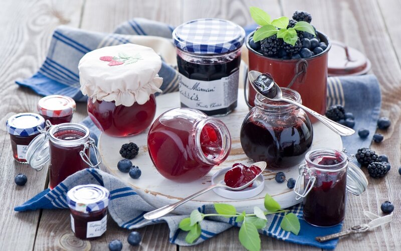 Assorted fruit jams on wooden table