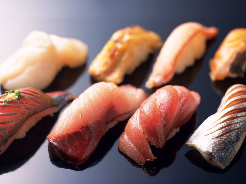 Assorted sushi pieces on black plate