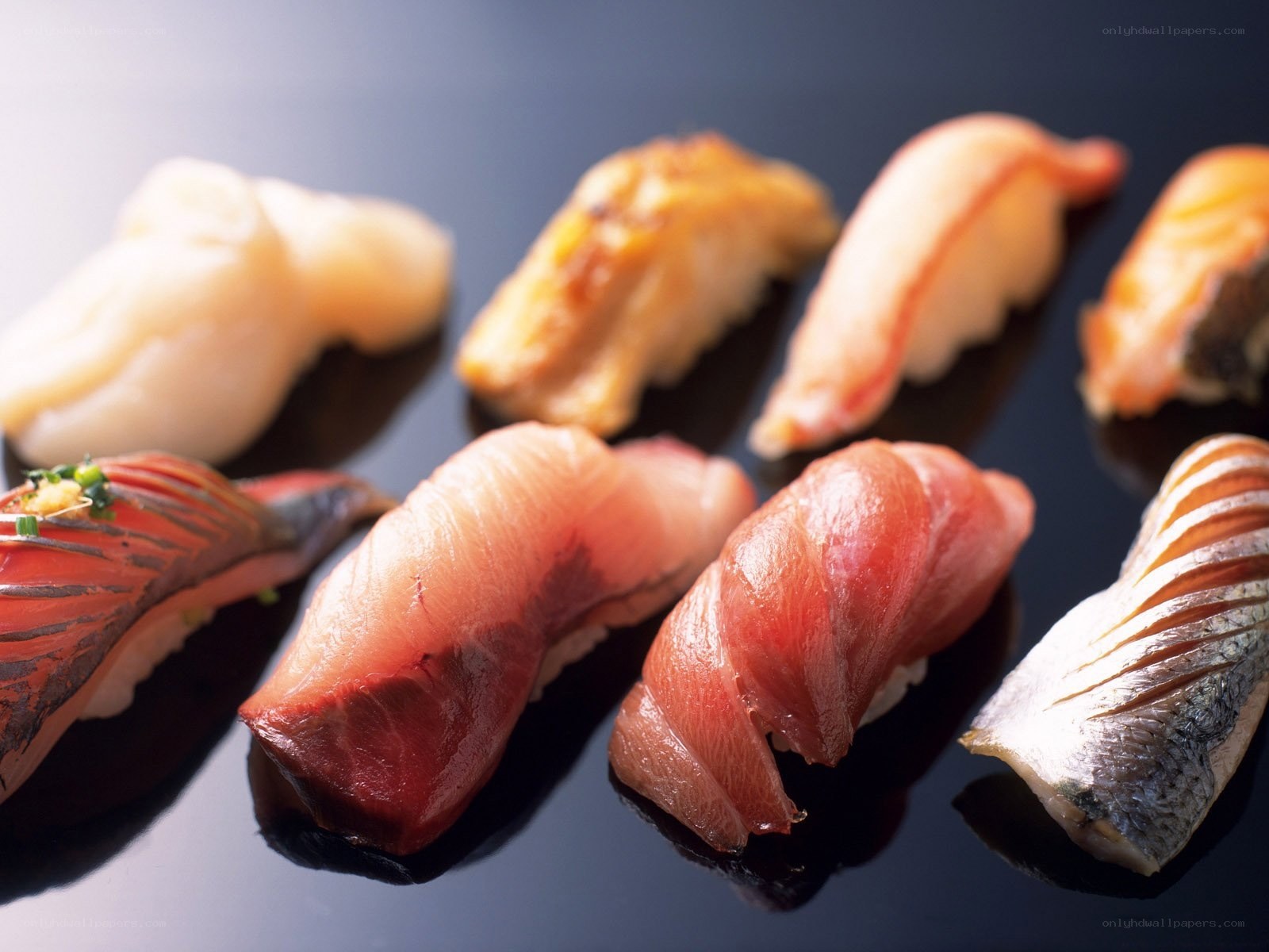 Assorted sushi pieces on black plate