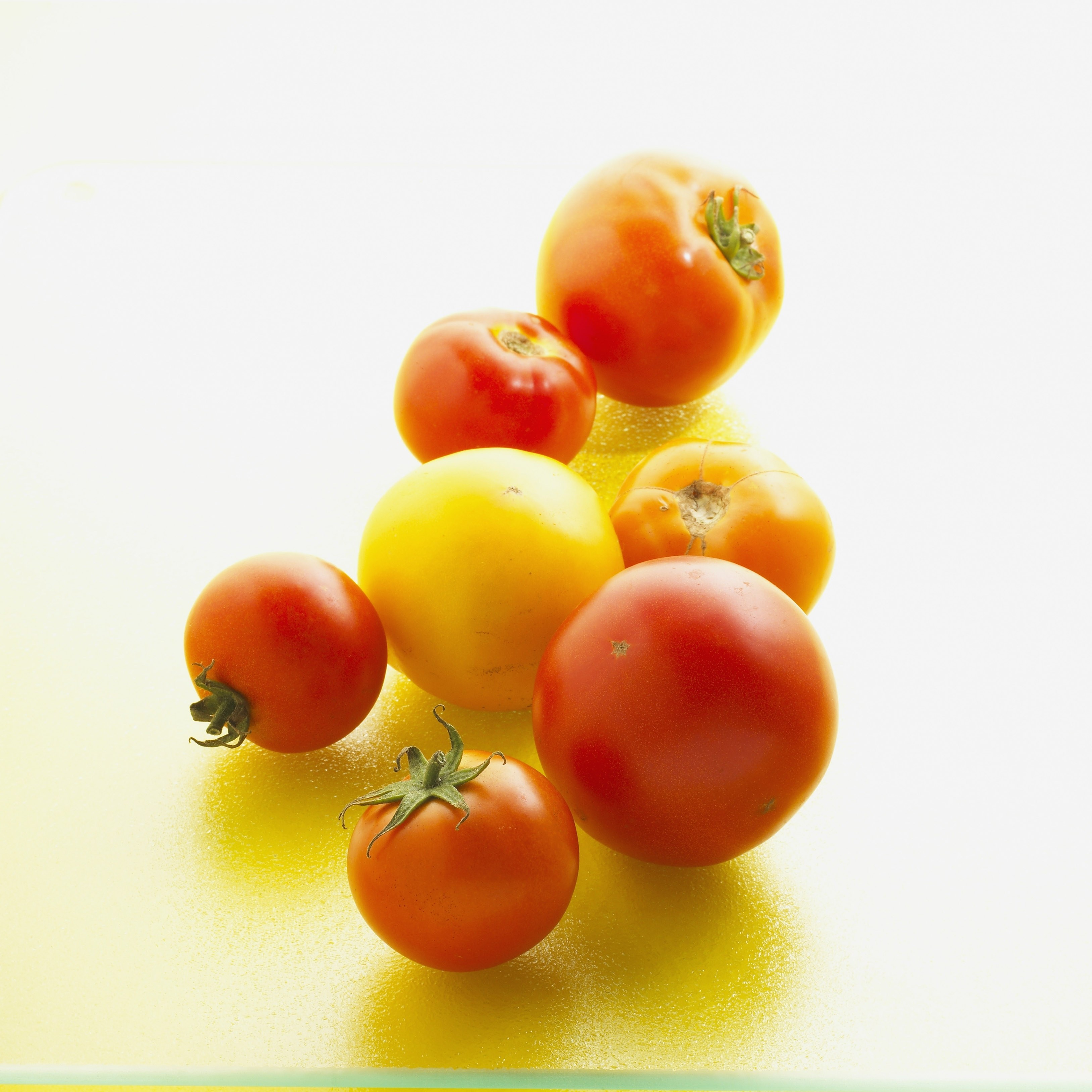 Assorted tomatoes on yellow surface