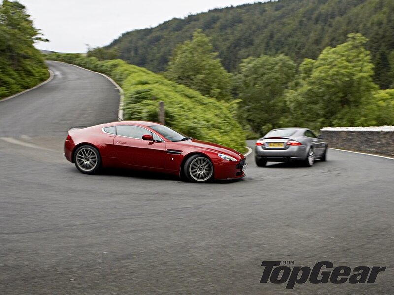 Aston Martin and Jaguar on a winding road