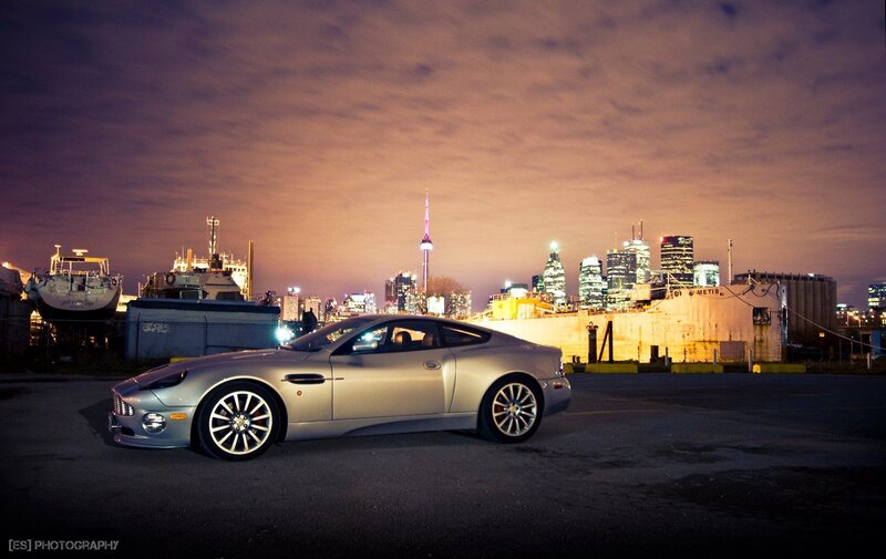 Aston Martin at night with city skyline