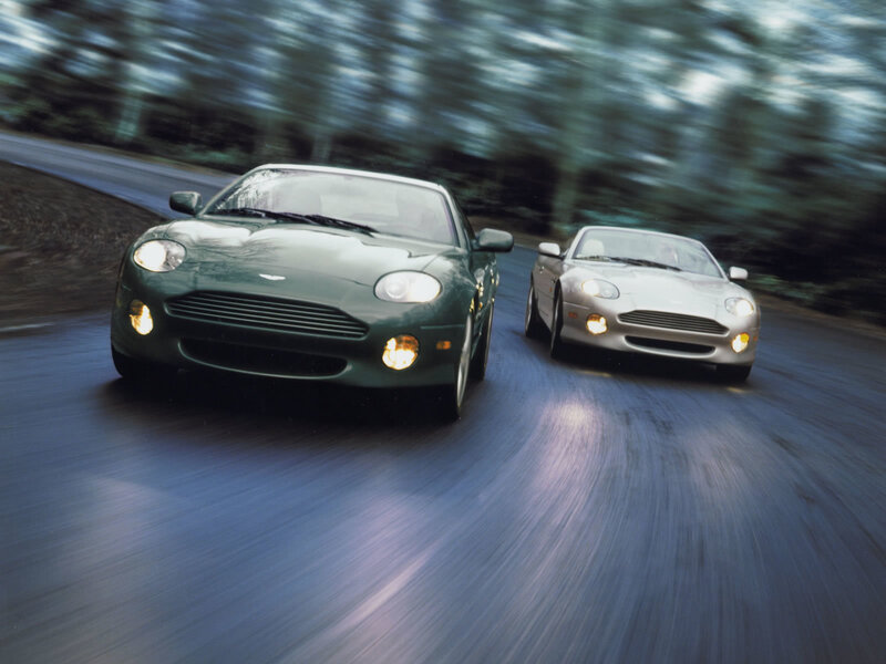 Aston Martin cars on a road