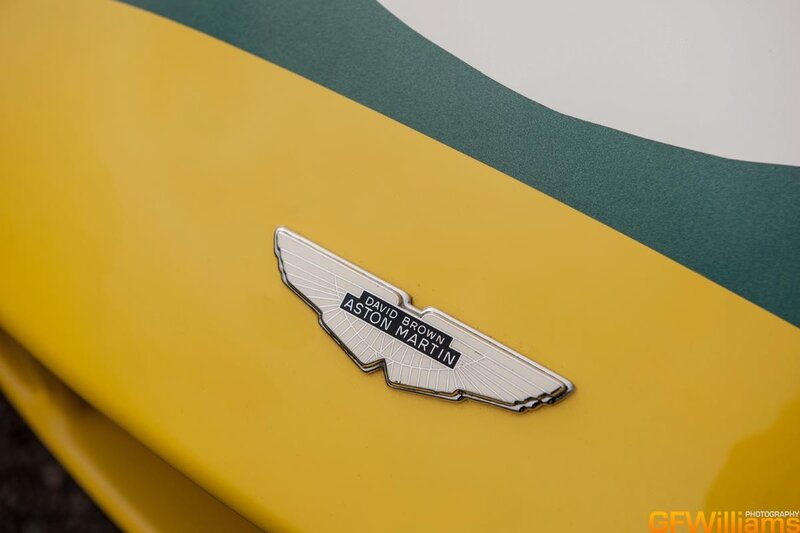 Aston Martin emblem on yellow car