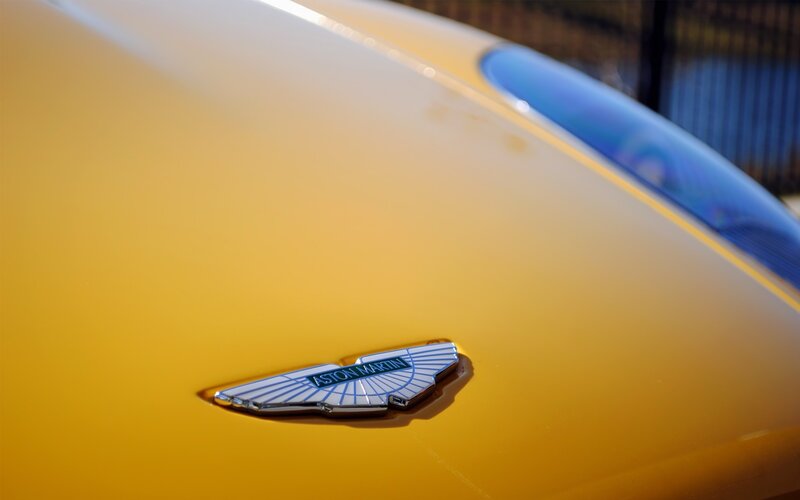 Aston Martin emblem on yellow car