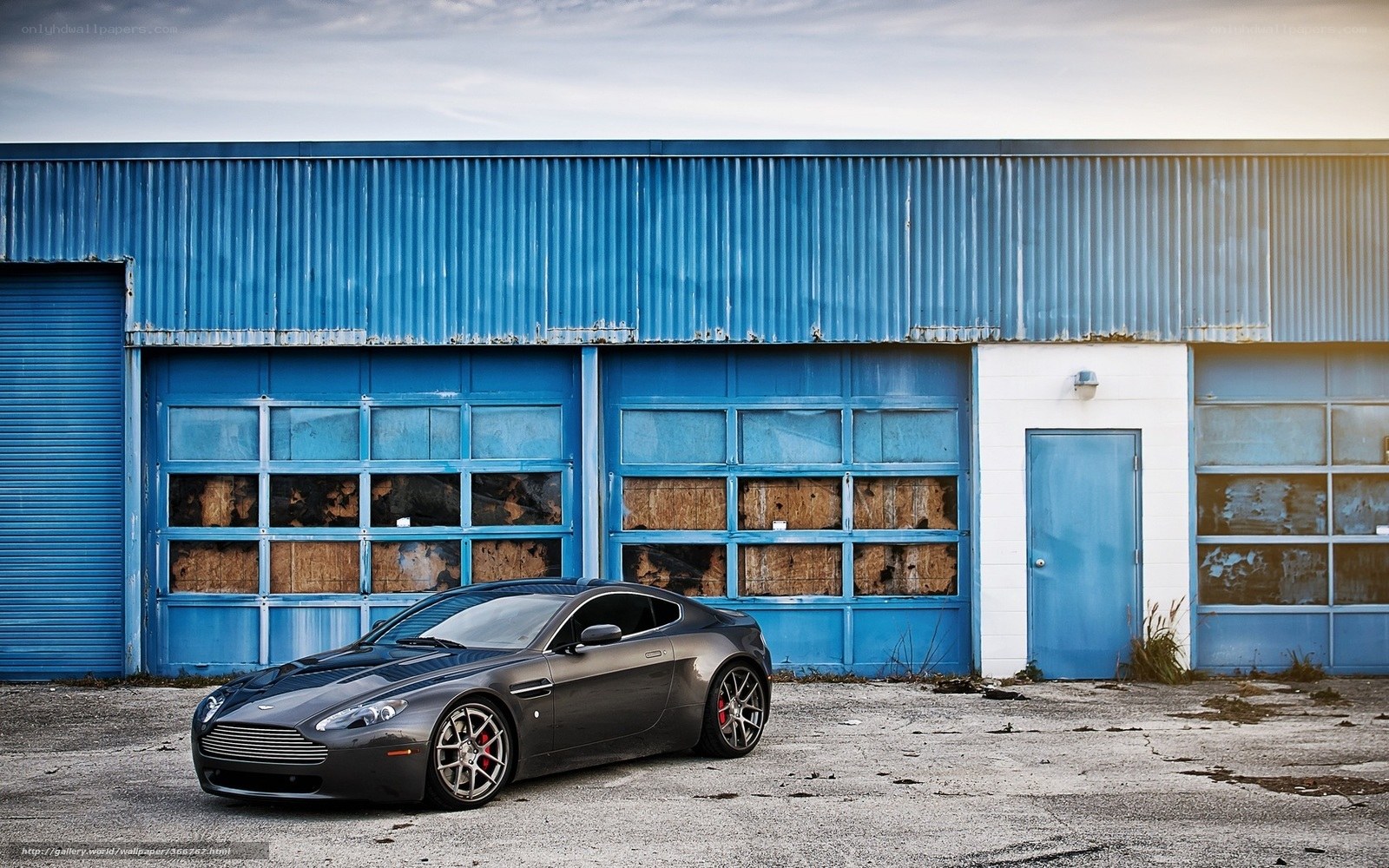 Aston Martin in front of a blue garage