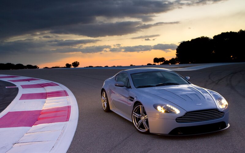 Aston Martin on a racetrack at sunset