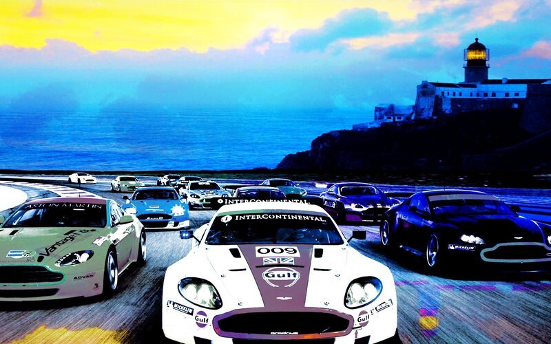 Aston Martin race cars at sunset