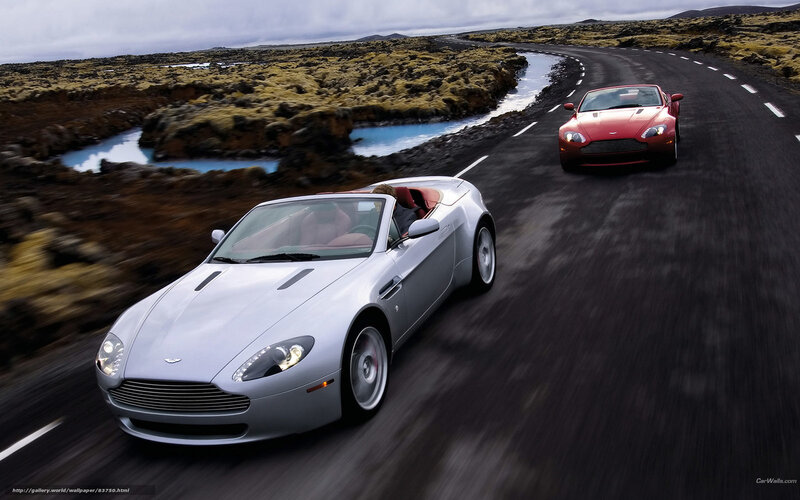 Aston Martin sports cars on a scenic road