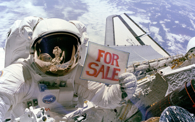 Astronaut holding for sale sign