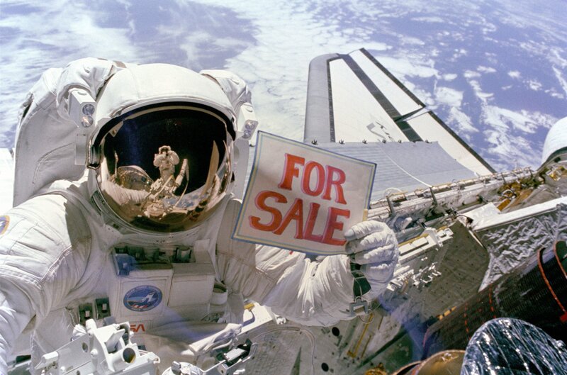 Astronaut holding for sale sign