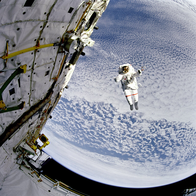 Astronaut in space near satellite