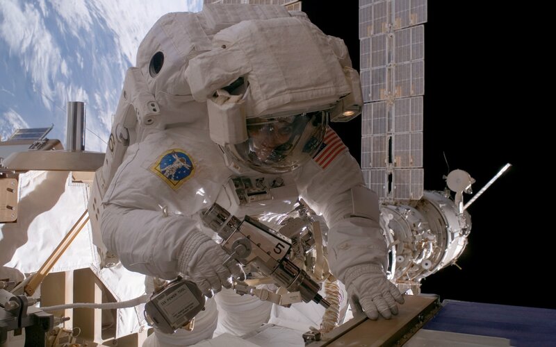 Astronaut in Space Suit — White, Dramatic, Photograph, Earth, Space Station, Solar Panels, Blue, Black