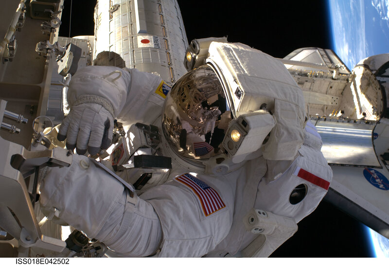 Astronaut in Space Suit — White, Dramatic, Photograph, Space Station, Earth, Solar Panels, Blue