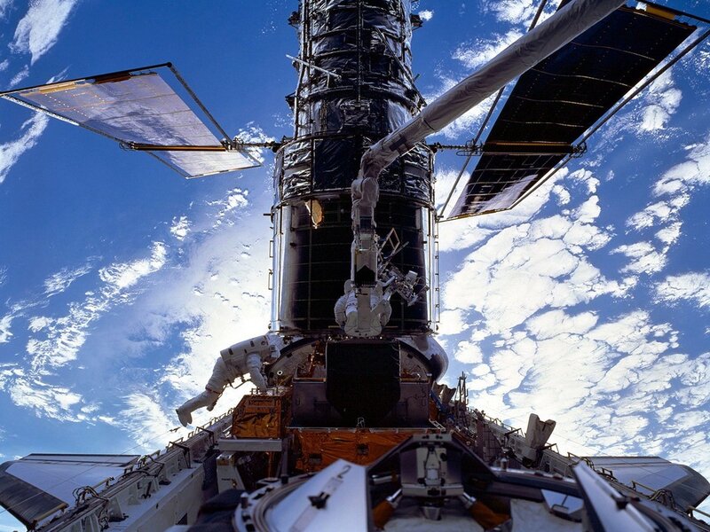 Astronaut servicing a satellite