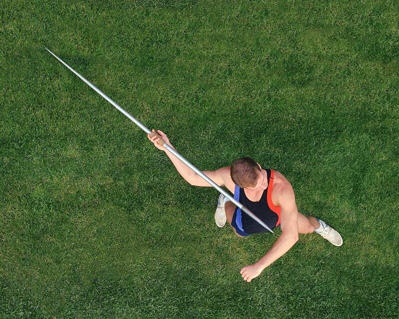 athlete holding javelin on grass