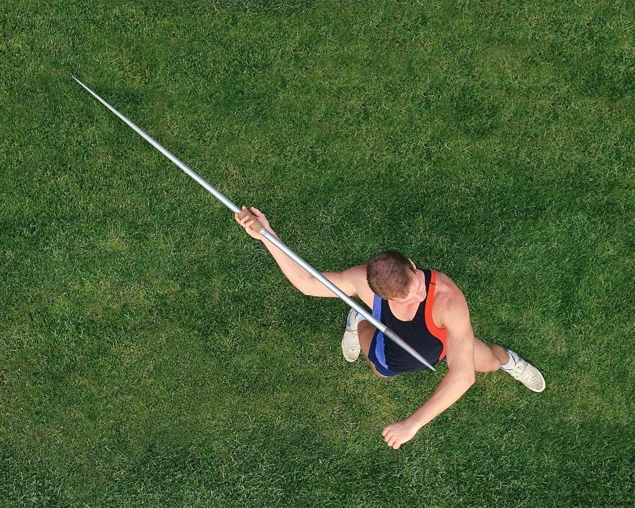 athlete holding javelin on grass