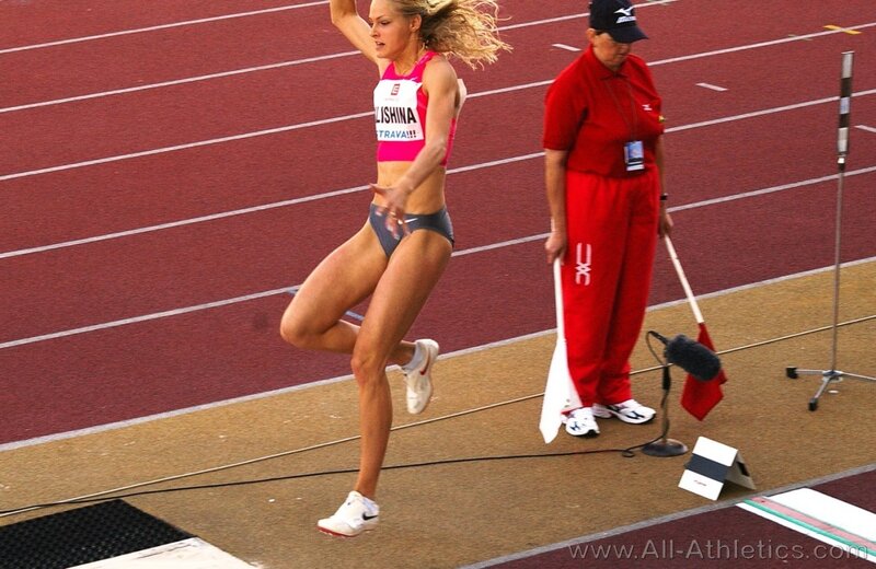 athlete in mid-jump on track