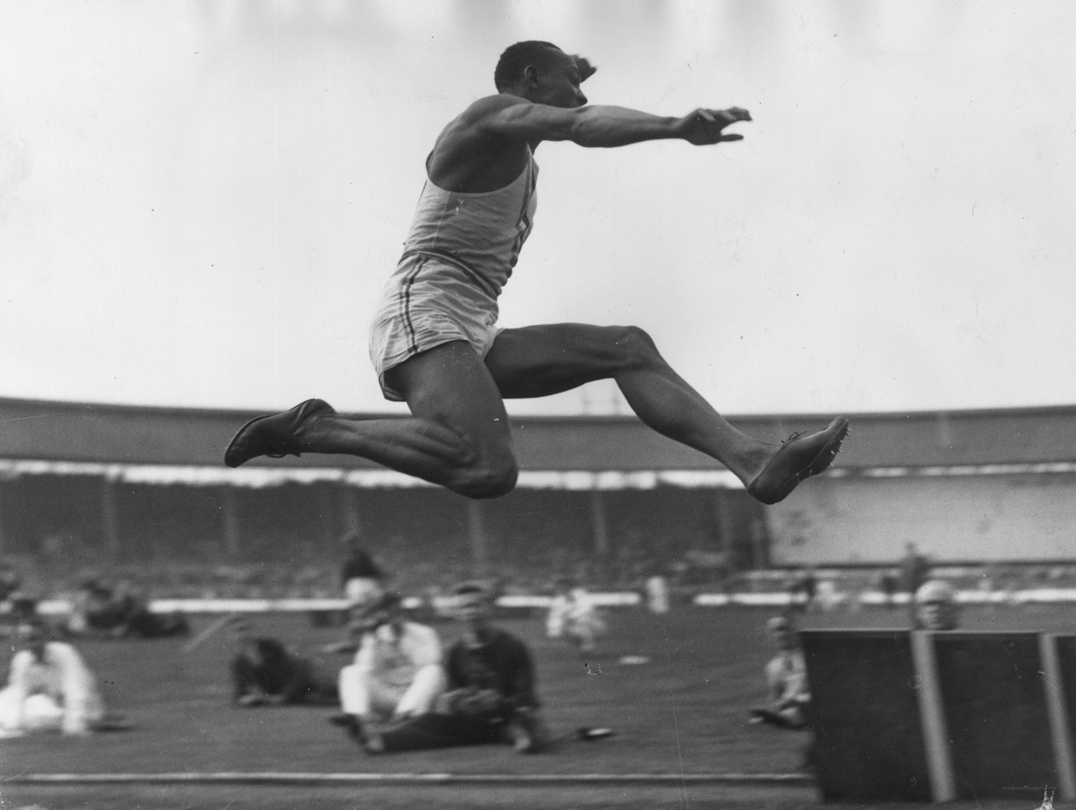 athlete mid-jump at stadium