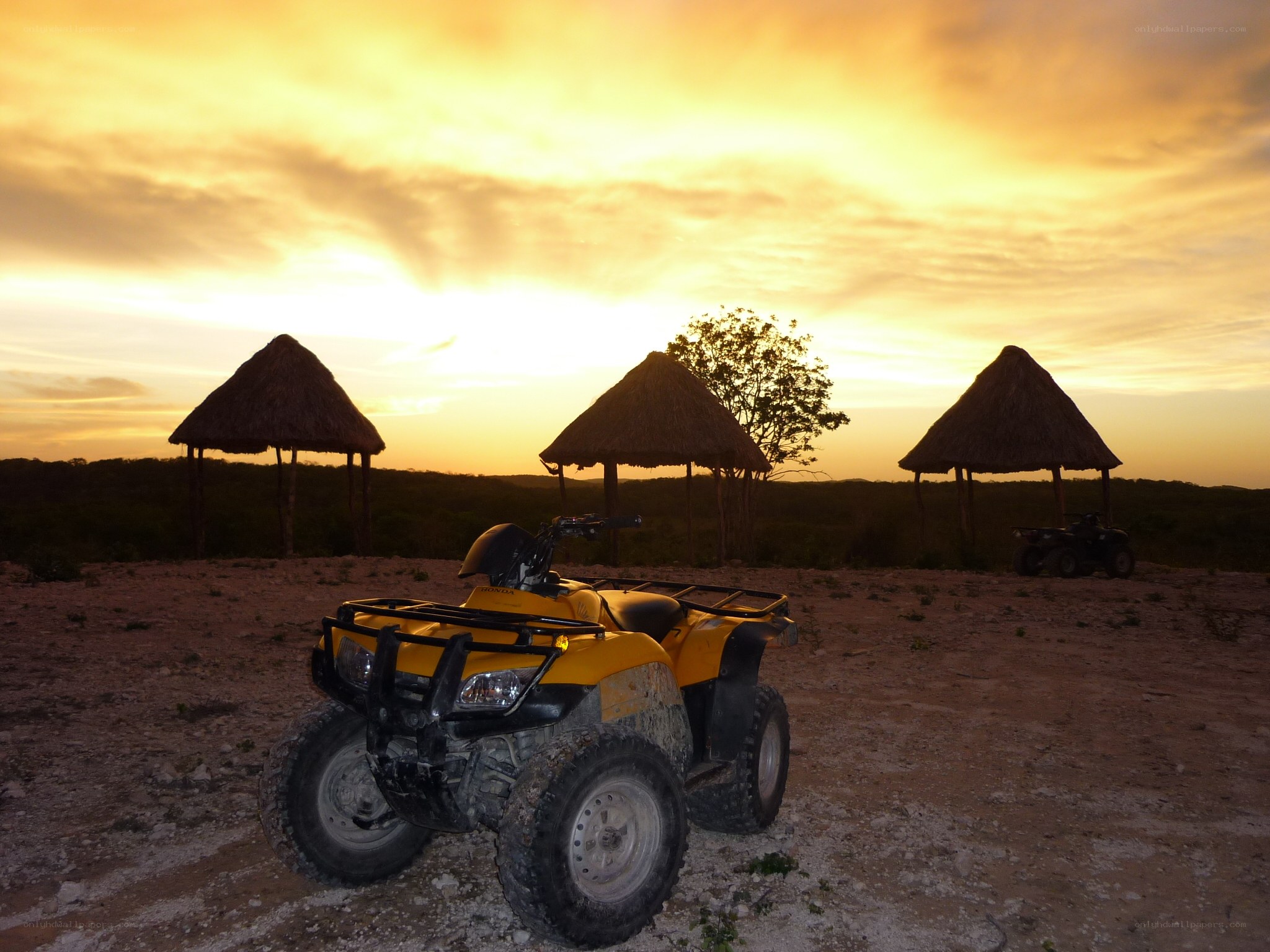 ATV at sunset with huts