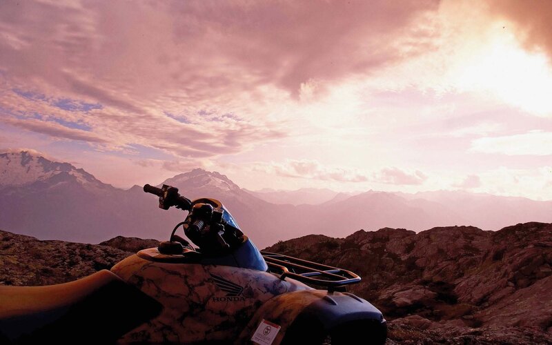 ATV on mountain peak at sunset