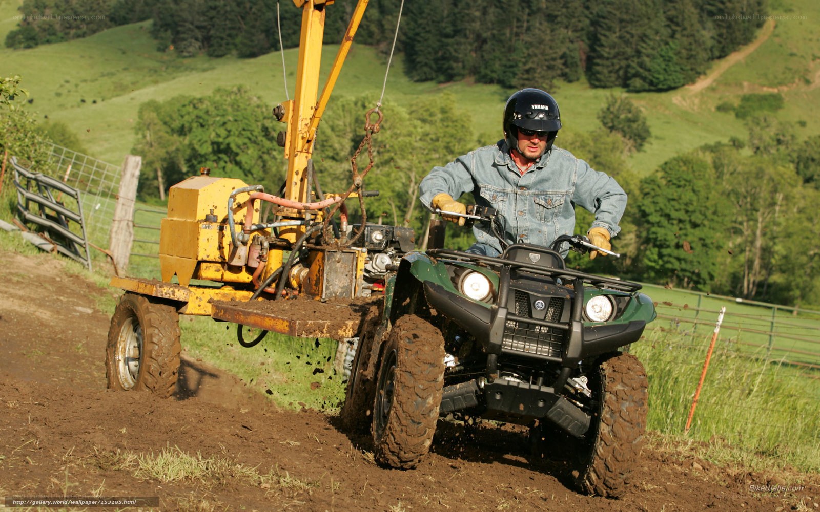 ATV pulling a post-hole digger