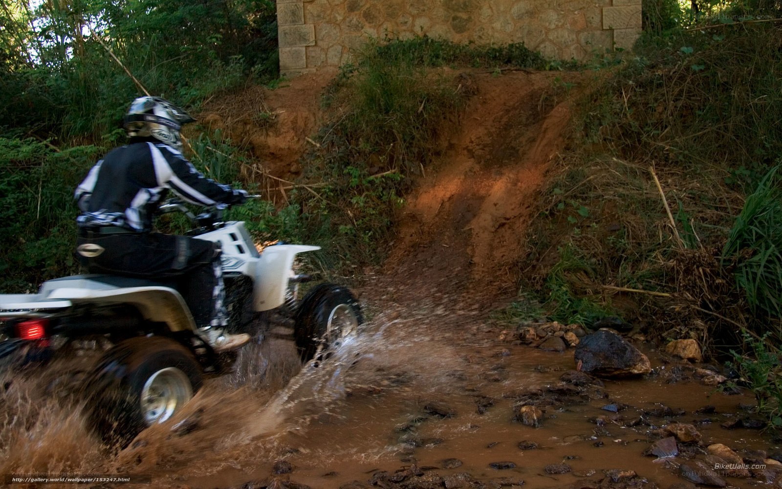 ATV rider crossing muddy stream