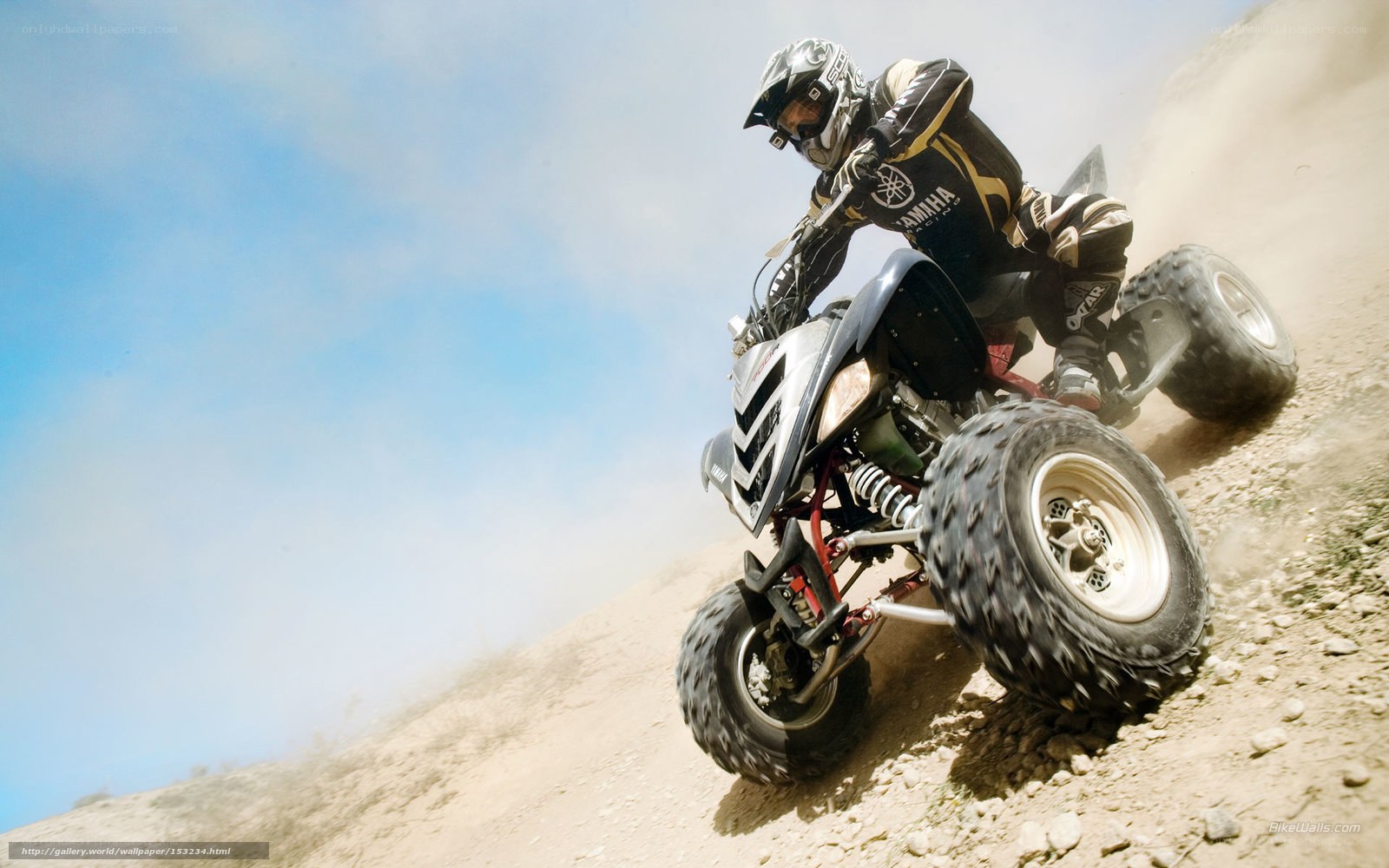 ATV rider on a dusty hill