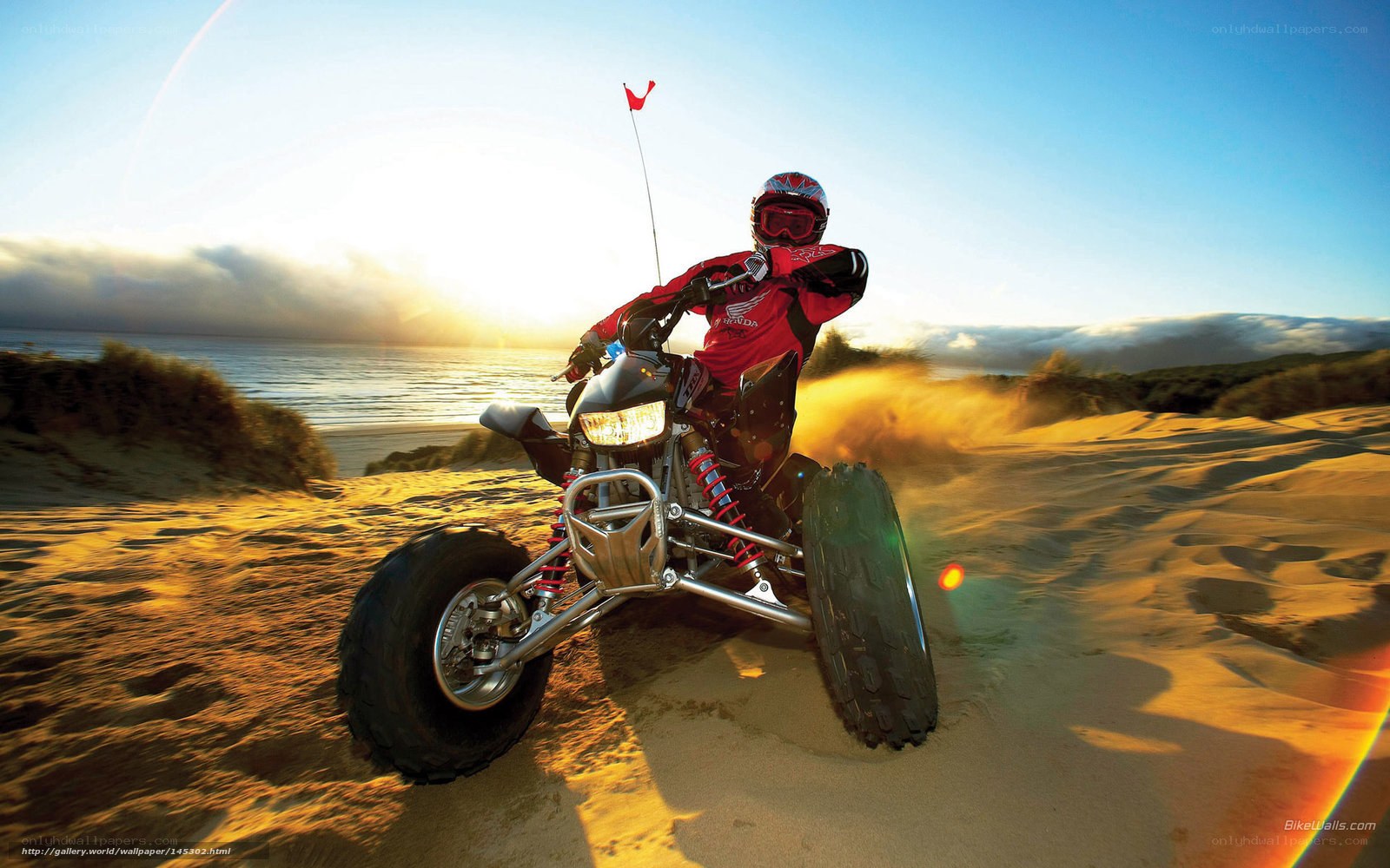 ATV rider on beach at sunset