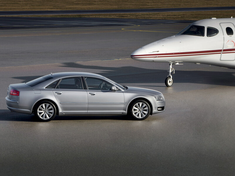 Audi A8 on tarmac with private jet